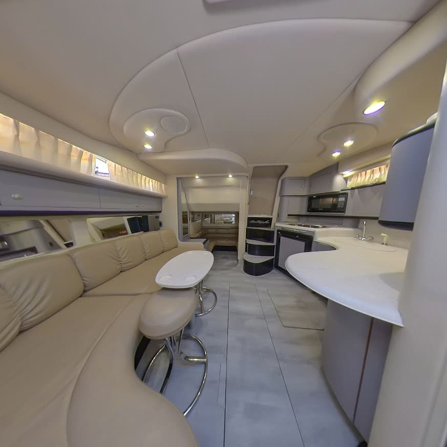 Interior cabin of the 40 Sea Ray yacht in Miami featuring cream leather seating, galley kitchen, and private lounge area
