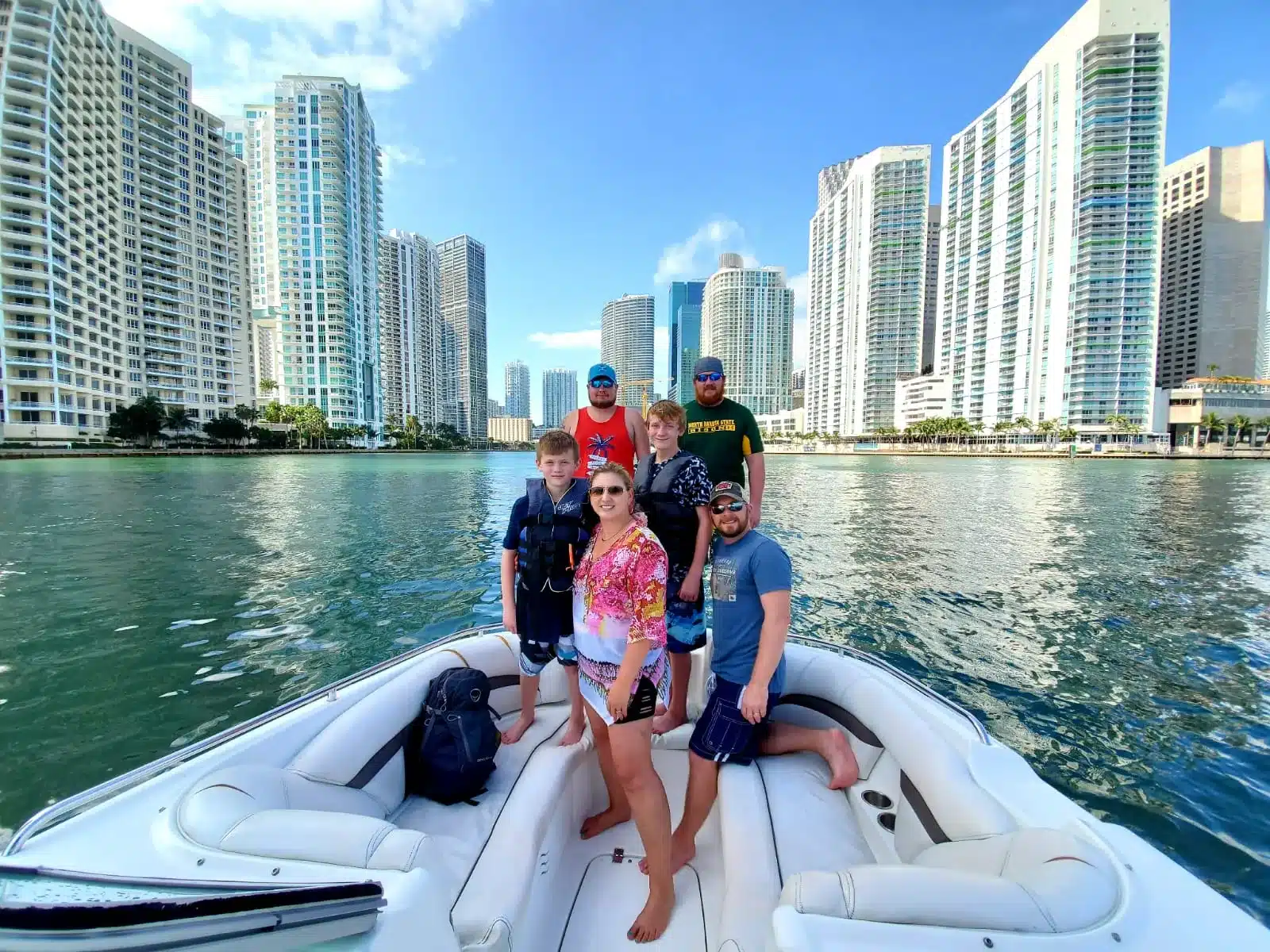 Family posing on the bow of a private Miami boat tour with downtown skyline behind them — Miami Tours and Water Adventures