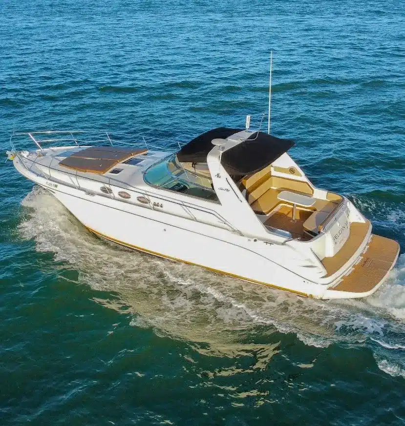 Aerial side view of the 40 Sea Ray sport yacht underway on open Miami water — full hull, teak deck, and hardtop