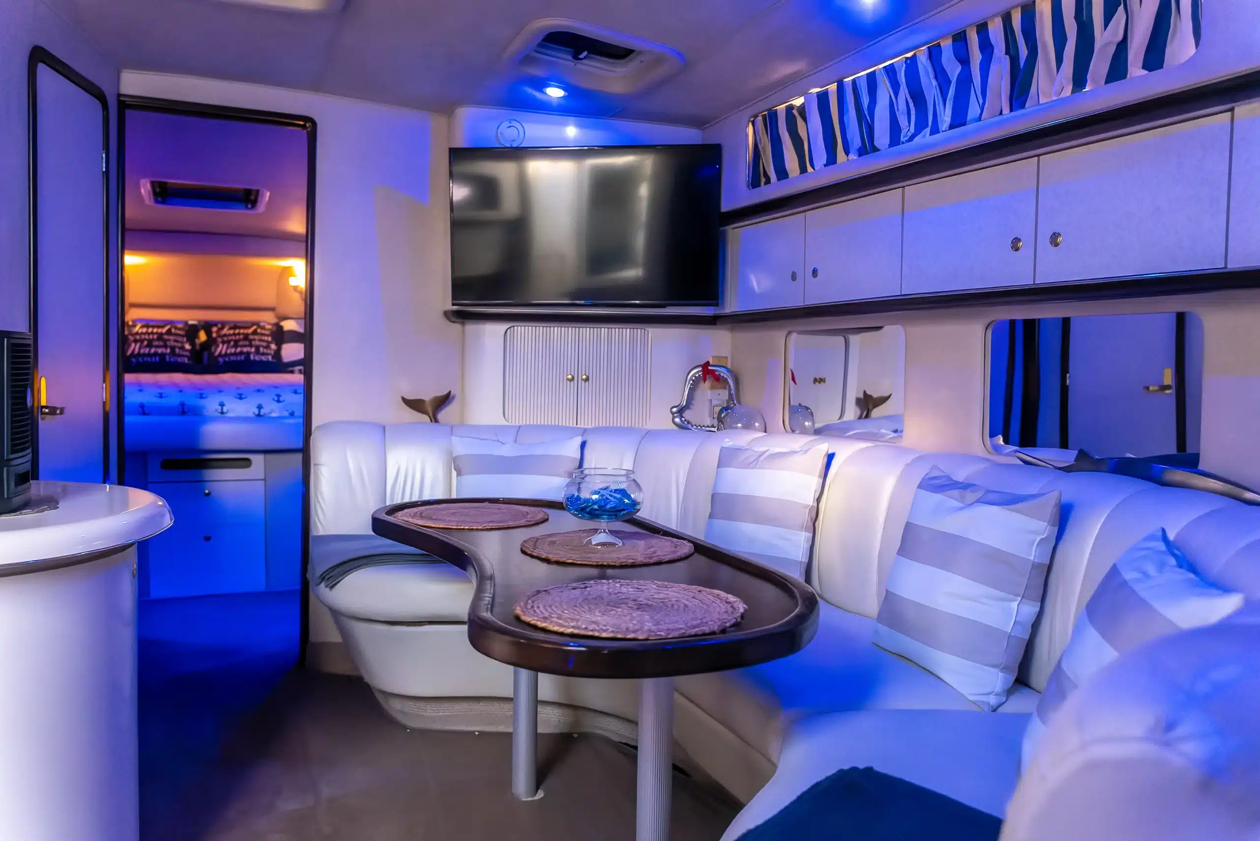 Salon interior on the 48 Sundancer — seating area with neon blue lighting, Miami private charter