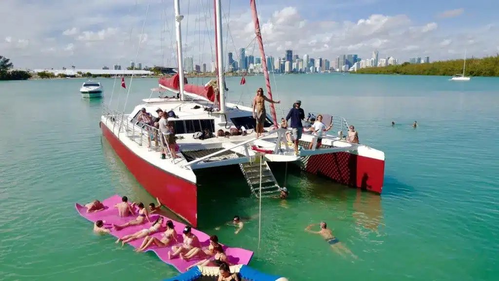 Mega catamaran on Biscayne Bay, Miami — crewed charter photographed from another vessel with downtown skyline