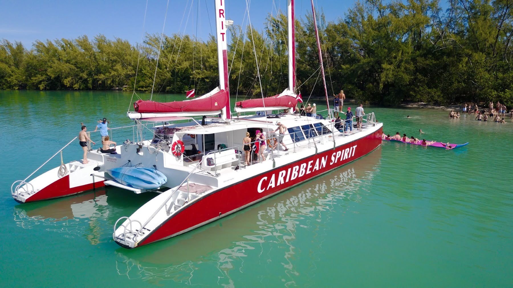 Aerial view of the Caribbean Spirit sailing catamaran with guests swimming in turquoise water