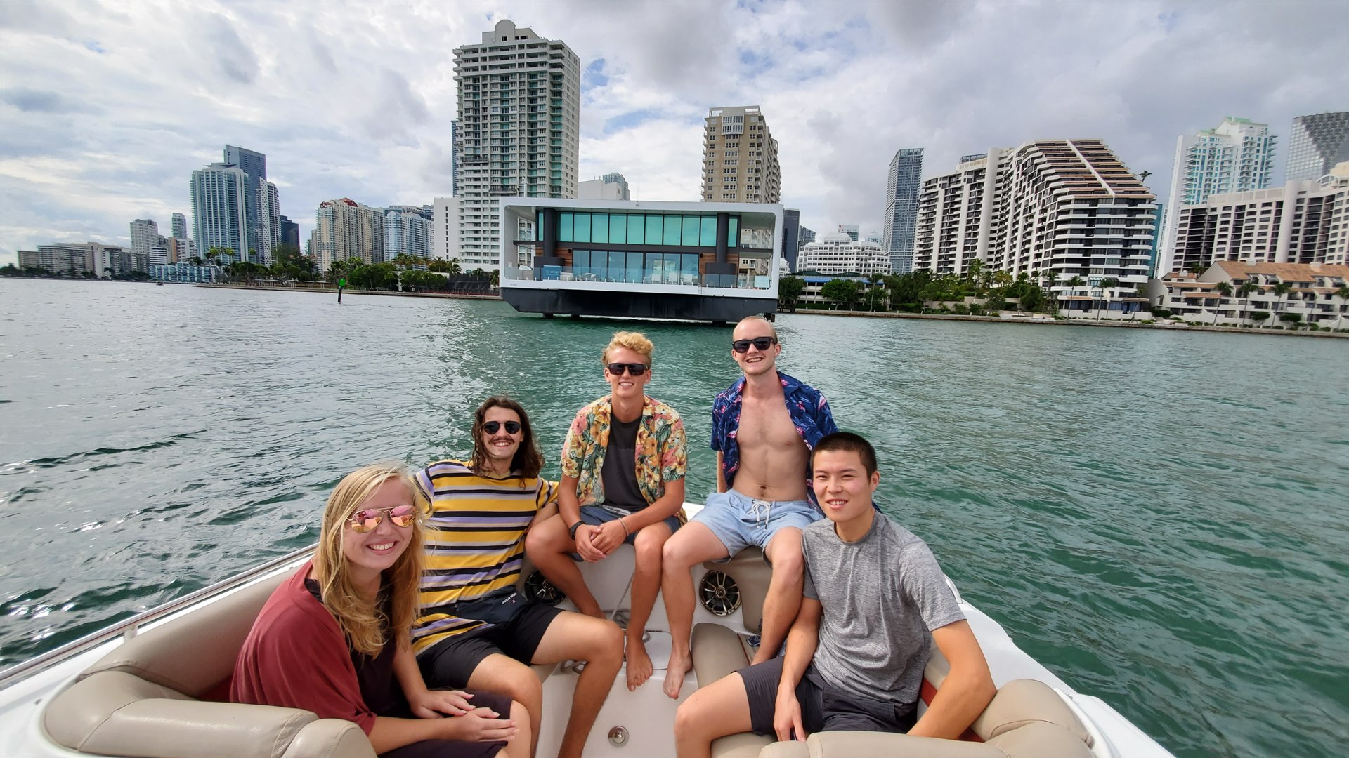 Guests seated on the bow of a private Miami boat with the downtown skyline behind them