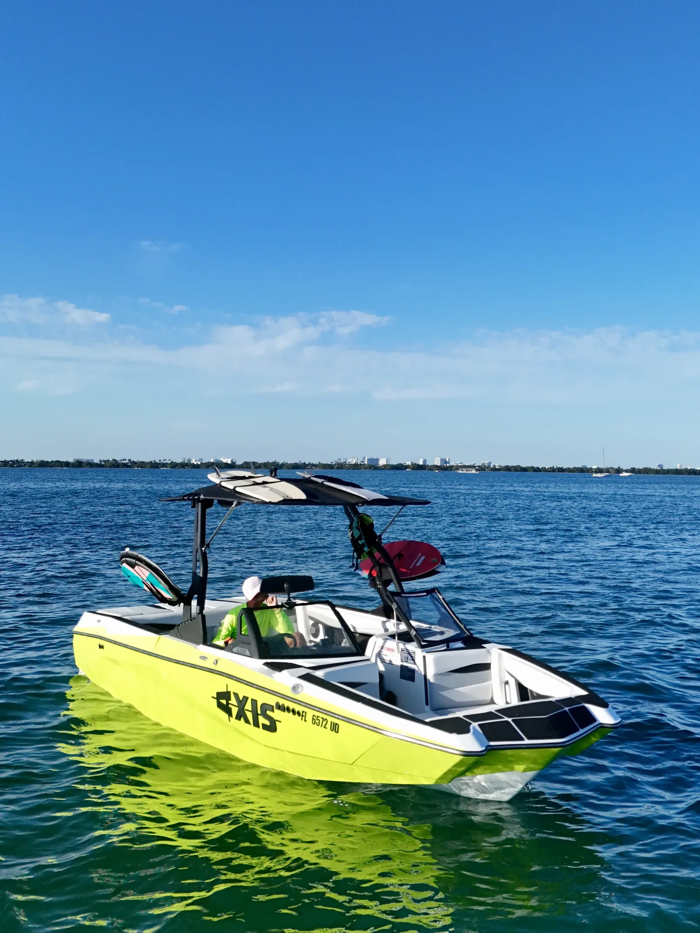 Aerial view of wake sports boat on Biscayne Bay with Miami skyline on the horizon