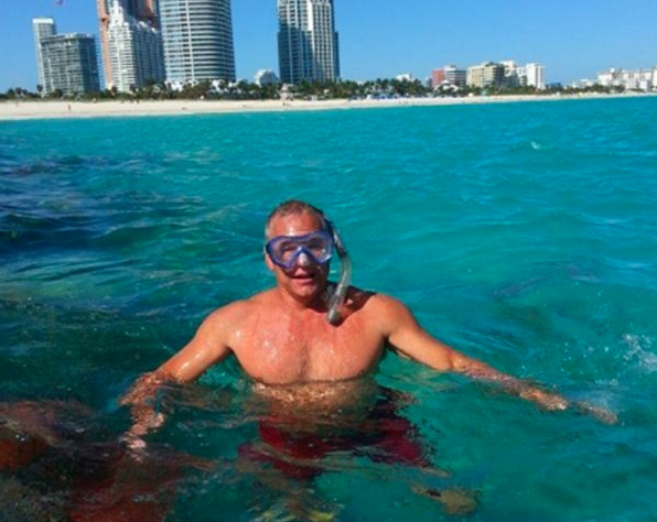 Three guests snorkeling in clear Biscayne Bay water near a mangrove island on a Miami private charter