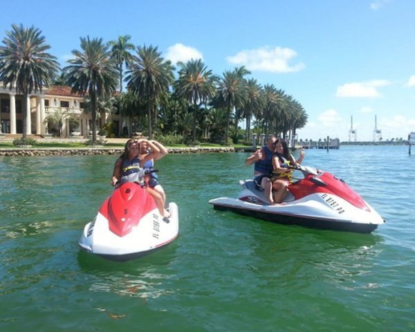 Two guests on a jet ski cruising past Miami bay islands on a guided tour