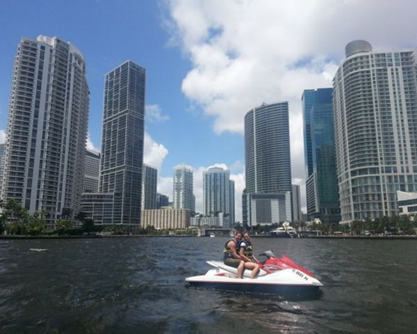 Jet ski riders on Biscayne Bay with the Miami skyline in the distance
