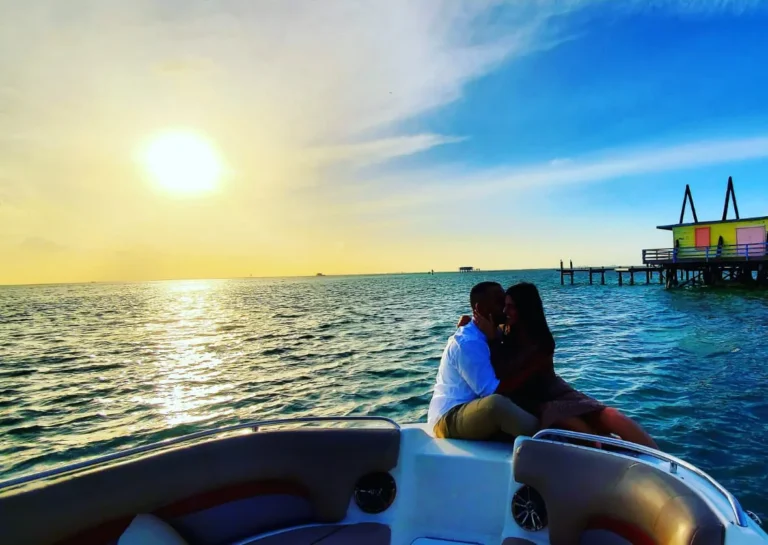 Couple sitting on a boat bow at sunset near a Biscayne Bay stilt house