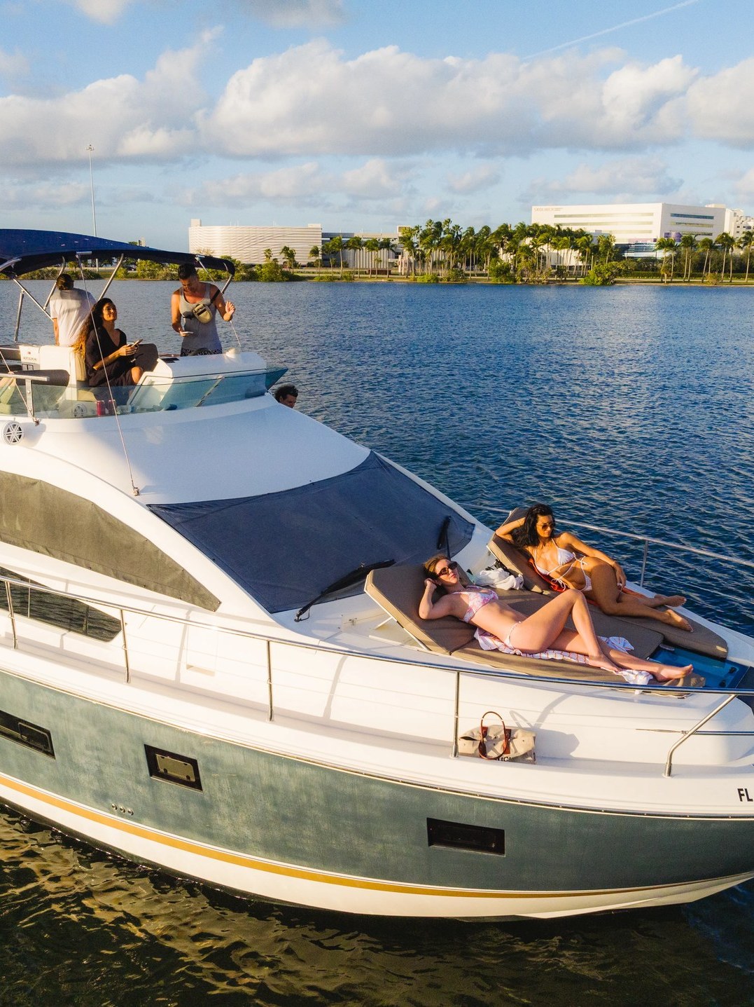 Guests on the bow sunpad of the 46 Flybridge with the flybridge helm above
