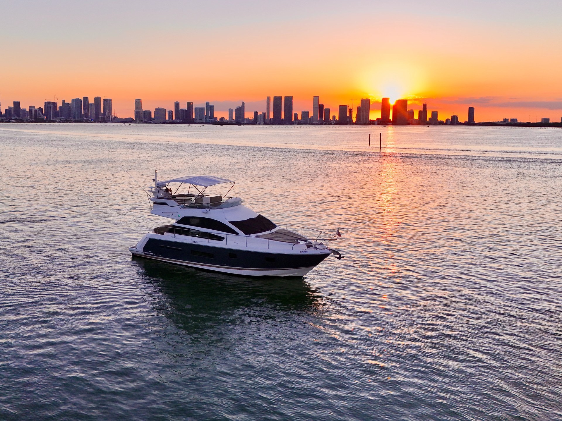 46 Flybridge cruising at sunset with the Miami skyline on the horizon