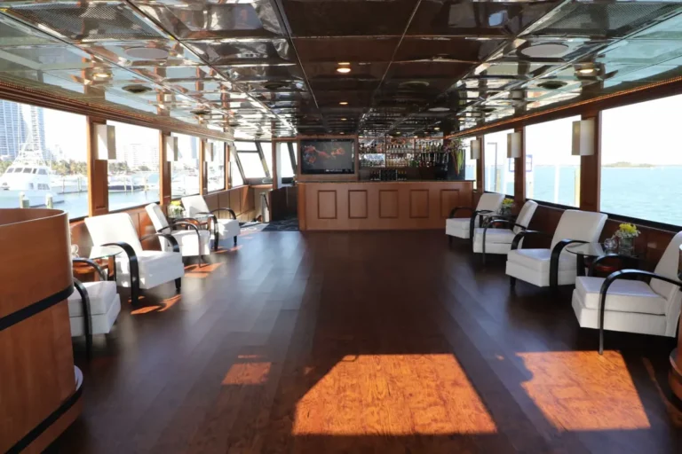 Upper deck club lounge with white club chairs and wood floors on the 100′ Midnight Sun yacht