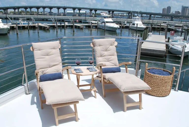 Teak loungers and wine on the open aft flybridge of the 80′ Solstice yacht, docked in Miami
